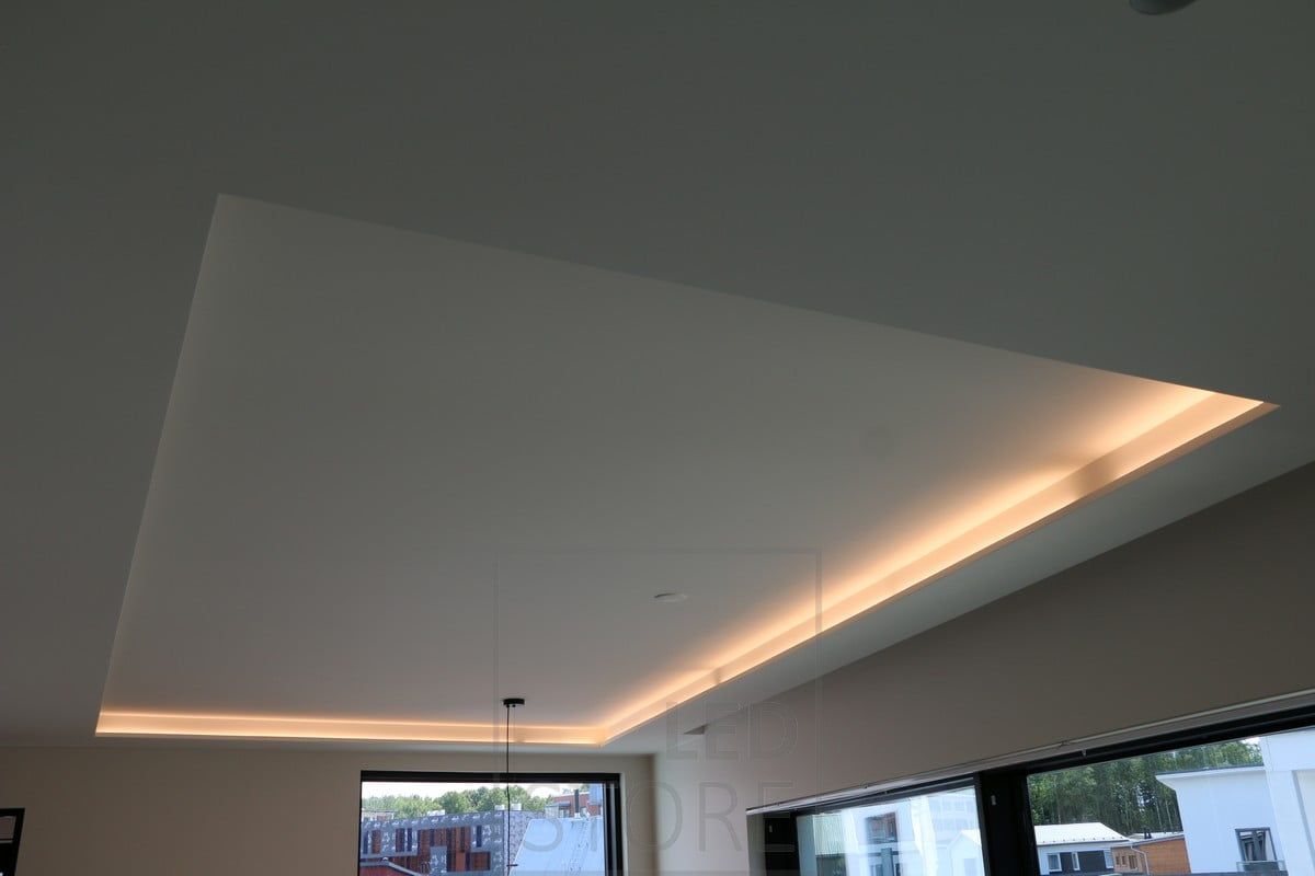 A LED strip mounted on the lip, indirectly illuminating the space through the ceiling, creating a soft mood lighting effect.